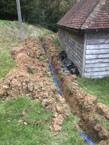 Irrigation pipework going in around a countryside building near Woods Corner